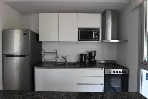 a kitchen with white cabinets and a stainless steel refrigerator at Carilo Vista in Carilo