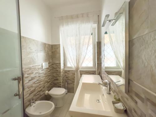une salle de bains avec lavabo, toilettes et miroir dans l'établissement Toto Vatican House, à Rome