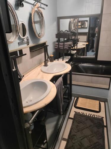 a bathroom with three sinks and mirrors at 2CH 4pers matelas M de Forme Kitchenette SDB WC au calme côté jardin in Tulle