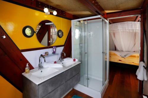 a bathroom with a shower and two sinks and a glass shower stall at La baignoire sur le toit 7 à 8 personnes in La Trinité