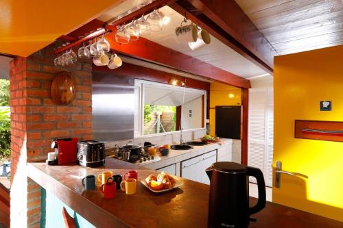 a kitchen with yellow walls and a counter top at La baignoire sur le toit 7 à 8 personnes in La Trinité