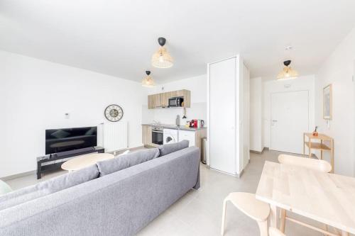 un salon avec un canapé et une table dans l'établissement L'Elégant de Paris - Villepinte - Paris, à Villepinte