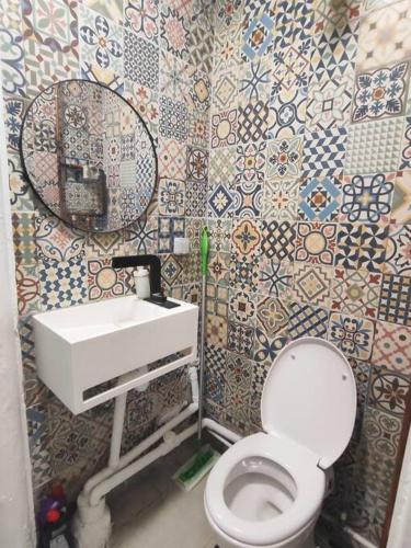 a bathroom with a white toilet and a sink at Chez Caramel à Vincennes in Vincennes