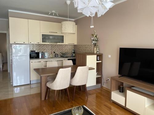 a kitchen with a wooden table and white appliances at Workation Panorama Escape in Budva