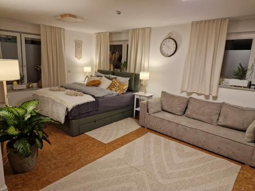 a bedroom with a bed and a couch and a clock at Ferienwohnung Nachtigall 3 in Bad Hersfeld