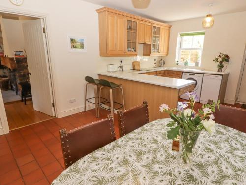 a kitchen with a table with a vase of flowers on it at Clearbrook Lodge in Carmarthen