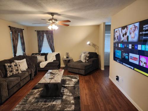 a living room with couches and a flat screen tv at Laribond's Place Houston Texas in Houston