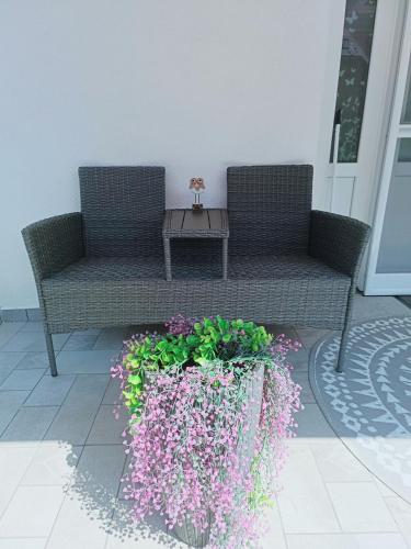 a patio with two chairs and a table and flowers at Búj-Lak Vendégház in Zalaszentmárton