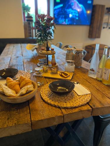 een houten tafel met een kom brood erop bij LE RELAIS DES CALECHES - La Jungle Room in Broué