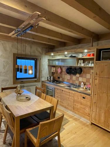 Una cocina con una mesa de madera y un comedor. en Vila Bijela , jacuzzi & sauna, en Jahorina