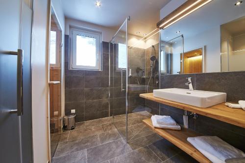 a bathroom with a sink and a shower at Appartements Liebe Heimat in Saalbach Hinterglemm