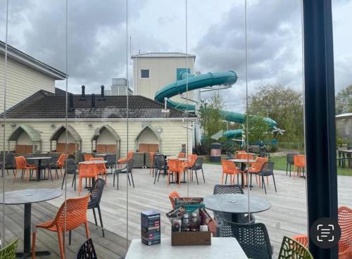 a playground with tables and chairs and a slide at Meadows 90 - Southview Holiday Park Skegness in Skegness