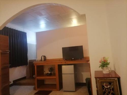a living room with a tv on a wooden table at Private well priced Guesthouse available to rent in Koh Phangan