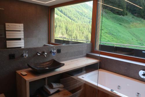 a bathroom with a sink and a large window at Rumwaldhof - Wohnung Calendula in Solda