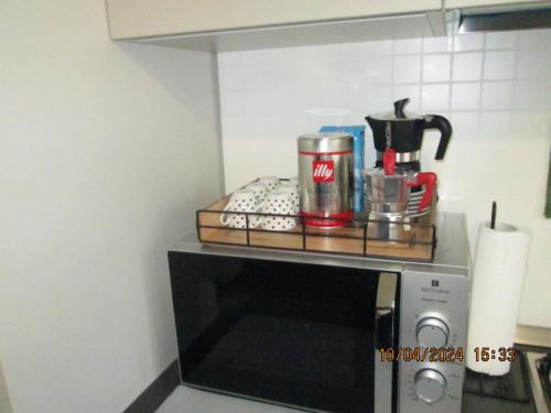 a shelf on top of a microwave in a kitchen at B & B SENTIERO VALTELLINA in Castello dellʼAcqua