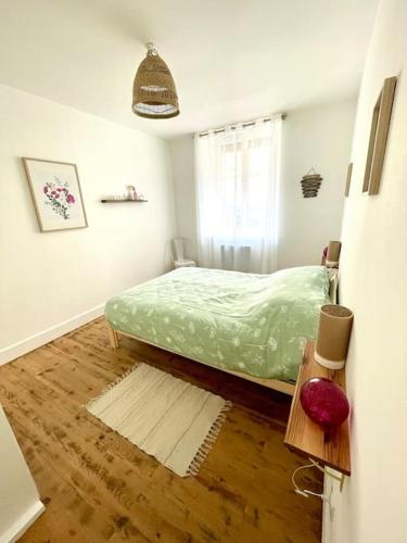 a bedroom with a green bed and a window at Logement cosy et jardin in Saint-Laurent-en-Royans