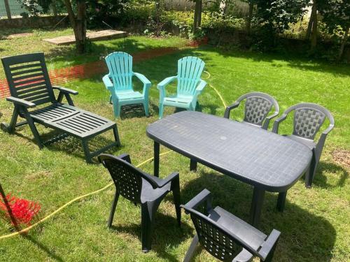 a group of chairs and a table and a table and chairs at Logement cosy et jardin in Saint-Laurent-en-Royans