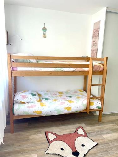 a childs bunk bed with a wooden fox rug on the floor at Logement cosy et jardin in Saint-Laurent-en-Royans