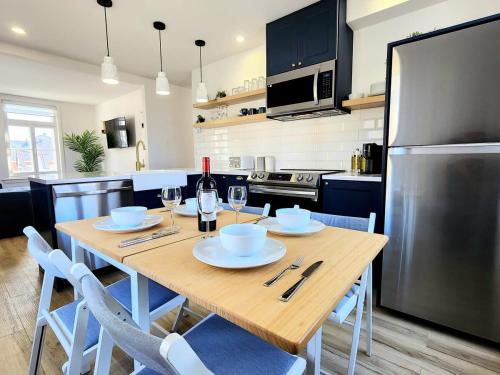 a kitchen with a wooden table with chairs and a refrigerator at 1900s Historic Charm -Free P+AC in Boischâtel
