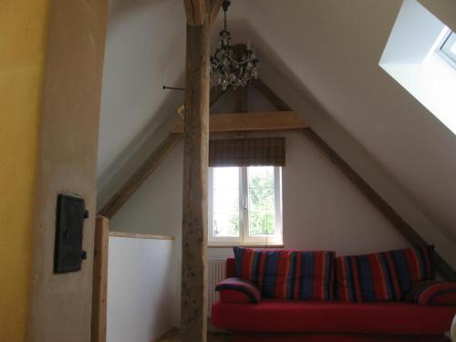 a living room with a red couch and a window at Ferienhaus am Lech in Kaufering