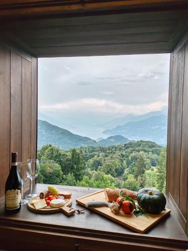 a table with food and a window with a view at Villa Chalet Bellagio Panorama in Bellagio