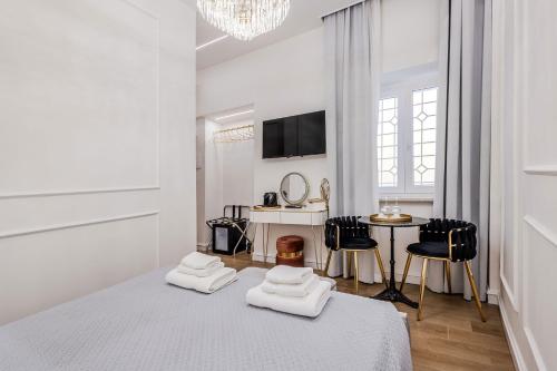 a white room with a bed and a table and chairs at Maison 31 - Junior Suite in Santa Marinella