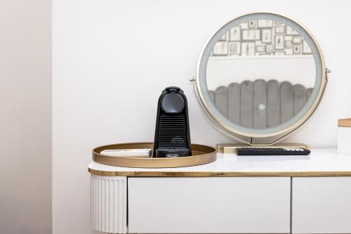 a remote control sitting on a white desk with a mirror at Maison 31 - Junior Suite in Santa Marinella