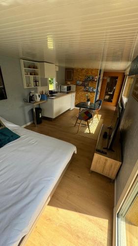 Cette chambre comprend un grand lit et une cuisine. dans l'établissement Oasis, à Juilley