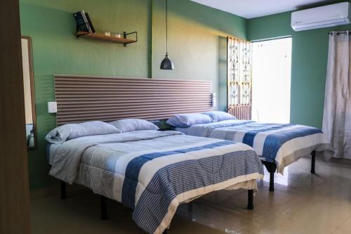 two beds in a bedroom with green walls at Remodeled Cozy Central 3 blocks from the Malecon in Mazatlán