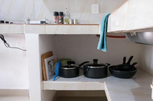 three pots sitting on a shelf in a kitchen at Remodeled Cozy Central 3 blocks from the Malecon in Mazatlán