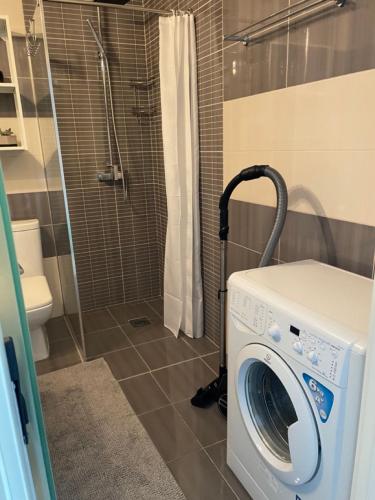 a washing machine in a bathroom with a shower at Workation Panorama Escape in Budva