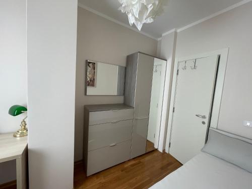 a white bedroom with a closet and a mirror at Workation Panorama Escape in Budva