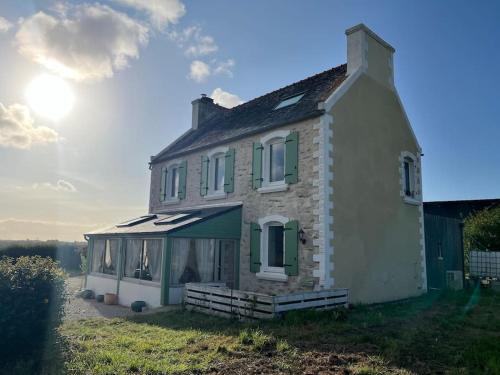 une maison où le soleil brille derrière elle dans l'établissement Maison de campagne 8pers proche Carantec, Morlaix, Roscoff, à Henvic