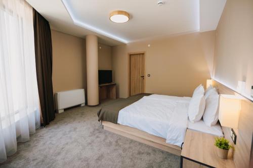 a hotel room with a bed and a television at Хотел Панорама in Pleven