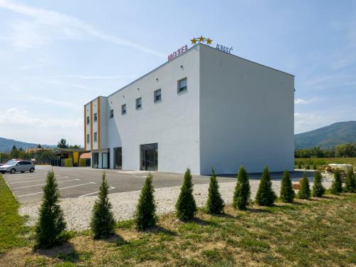 a building with a row of trees in front of it at Motel Anić in Novi Travnik