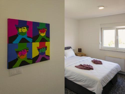 a bedroom with a painting on the wall next to a bed at Motel Anić in Novi Travnik