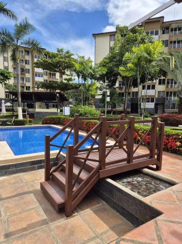 a wooden bridge in front of a swimming pool at Family getaway, pool, beach and surf in Jacó