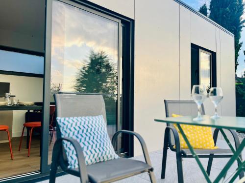 two chairs and a table on a patio at Coquette maisonnette - Vue Jet d'eau - Lac Léman in Bossey