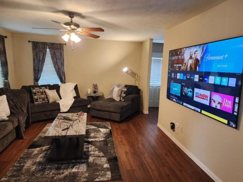 a living room with a large flat screen tv at Laribond's Place Houston Texas in Houston