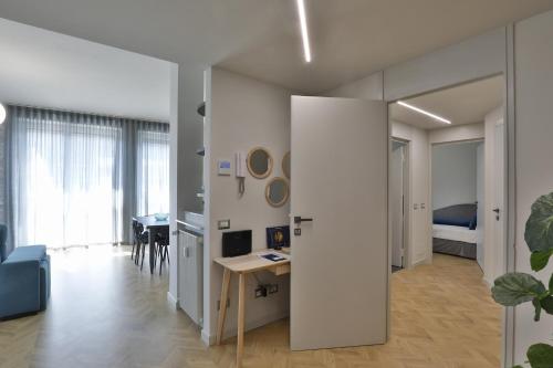a living room with a desk and a bedroom at Como Lake Suites in Como