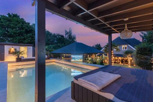 an outdoor pool with a bed and an umbrella at Blissfully Luxe Abode for Unforgettable Memories in Brighton & Hove
