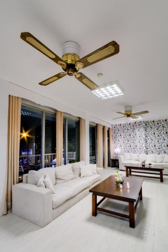 a living room with a couch and a ceiling fan at Hotel Royal in Colonia del Sacramento