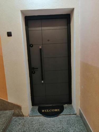 Una puerta de garaje con un cartel de bienvenida delante. en RUŽA Apartment, en Bitola