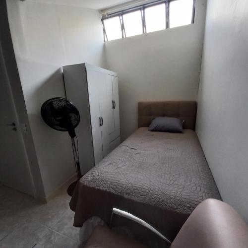 a small bedroom with a bed and a window at Apartamento 2 quartos Asa Norte com cozinha excelente localização in Brasilia