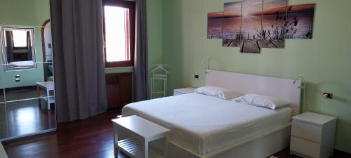 a bedroom with a white bed in a green room at Villa Giulia in Siracusa