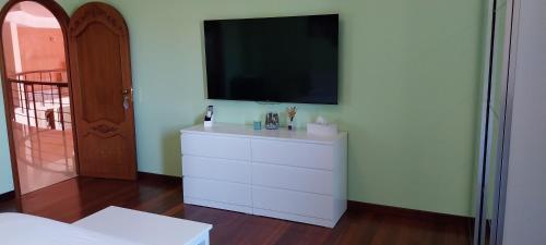 a white dresser with a television on top of it at Villa Giulia in Siracusa