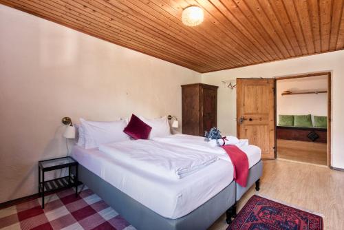 a bedroom with a large white bed with a wooden ceiling at Privatzimmervermietung Messner in Rifiano