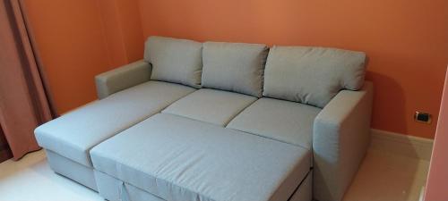 a white couch in a room with an orange wall at Villa Giulia in Siracusa