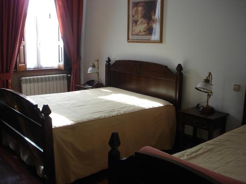 a bedroom with two beds and a window at Falcao de Mendonca in Figueira de Castelo Rodrigo
