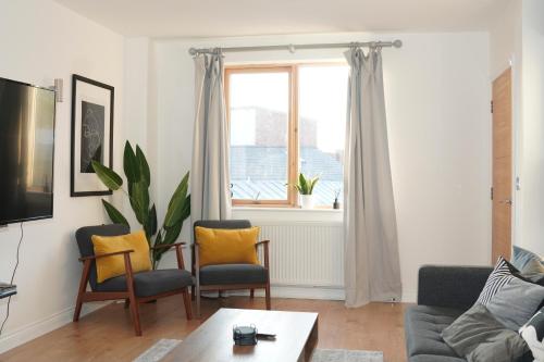 a living room with a couch and chairs and a window at Spacious 4BR 4BA gated townhouse with balconies, Central JQ in Birmingham